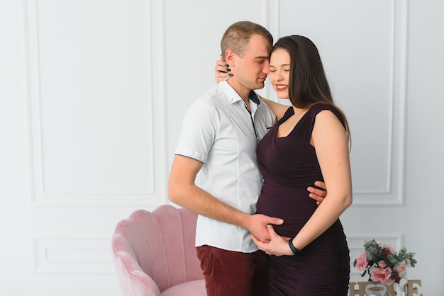 Giovane donna incinta con il marito in posa