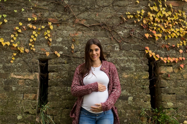 Giovane donna incinta nel parco autunnale