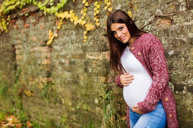 Giovane donna incinta nel parco autunnale