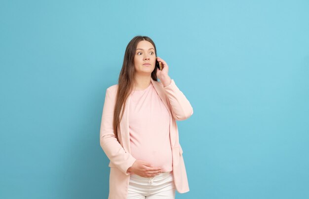 Giovane donna incinta, parlando al telefono