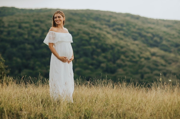 Giovane donna incinta rilassante fuori nella natura