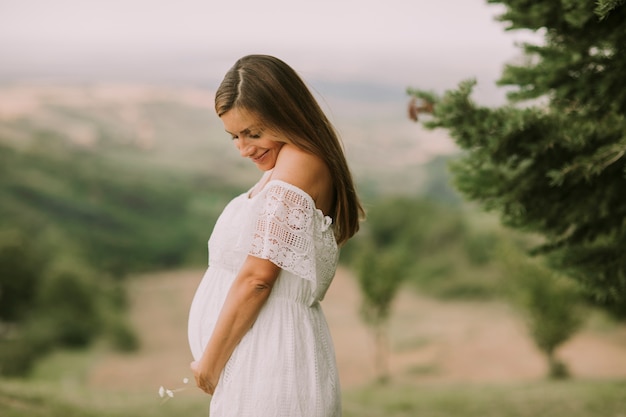 Giovane donna incinta rilassante fuori nella natura