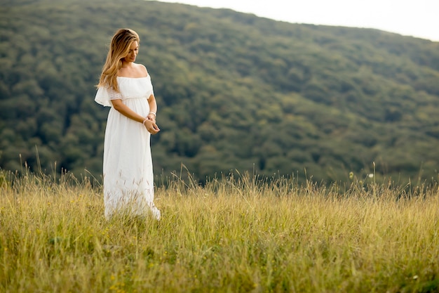 Giovane donna incinta rilassante fuori nella natura