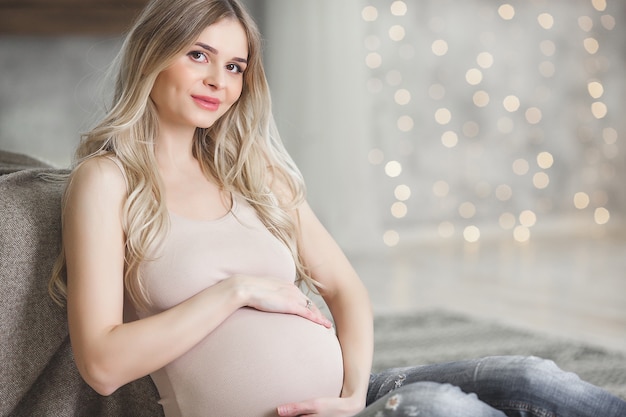 Giovane donna incinta su sfondo natalizio