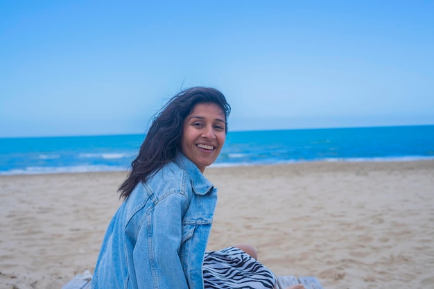 Giovane donna indiana felice in spiaggia