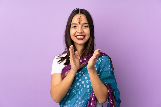 Giovane donna indiana isolata su porpora che applaude dopo la presentazione in una conferenza