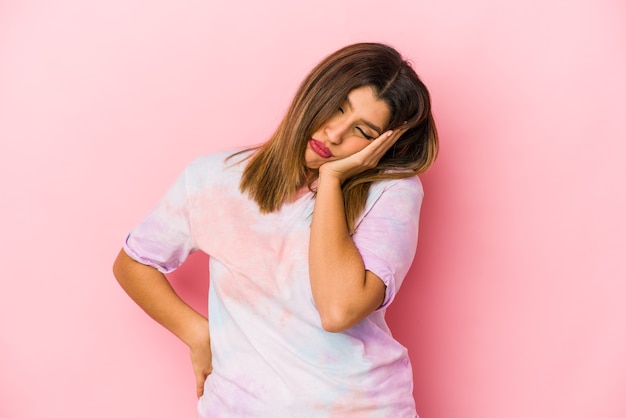 Giovane donna indiana isolata su sfondo rosa che è annoiata, affaticata e ha bisogno di una giornata di relax.