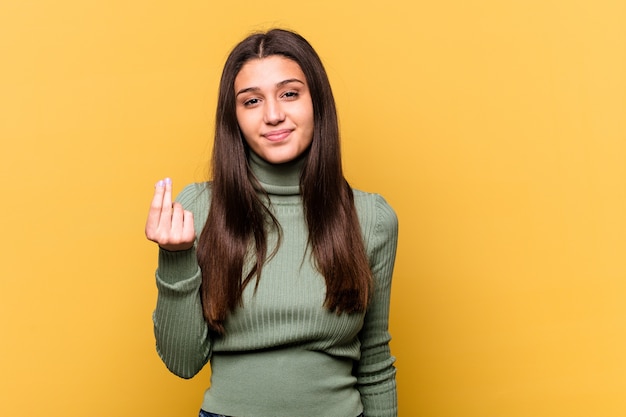 Giovane donna indiana isolata sul giallo che mostra che non ha soldi.