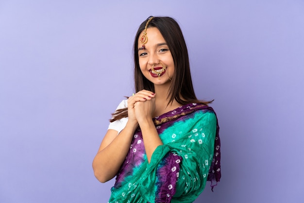Giovane donna indiana isolata sulla risata viola della parete