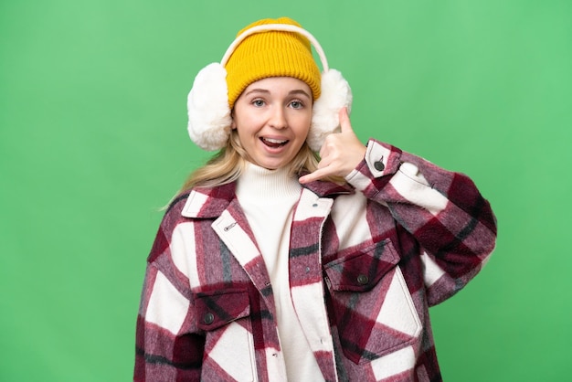 Giovane donna inglese che indossa manicotti invernali su sfondo isolato che fa il gesto del telefono Call me back sign