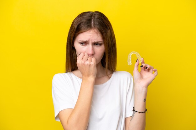 Giovane donna inglese che tiene bretelle invisibili che hanno dubbi