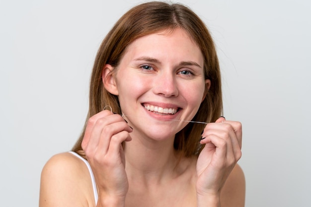 Giovane donna inglese che usa il filo interdentale con l'espressione felice Close up ritratto
