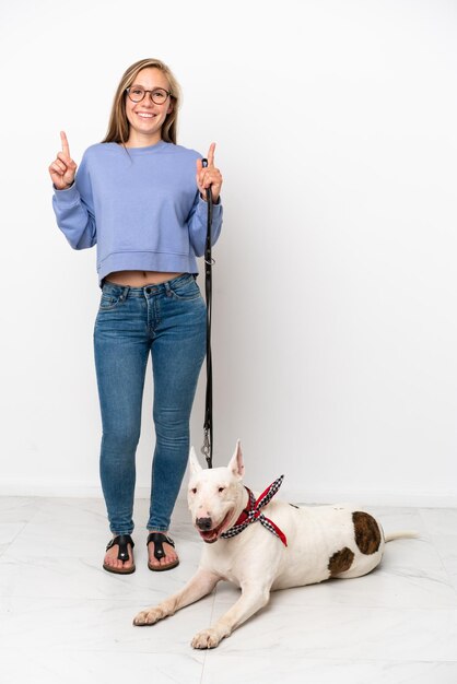 Giovane donna inglese con il suo cane isolato su sfondo bianco che indica una grande idea