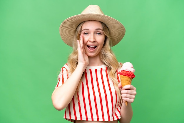 Giovane donna inglese con un cornetto gelato su sfondo isolato gridando con la bocca spalancata