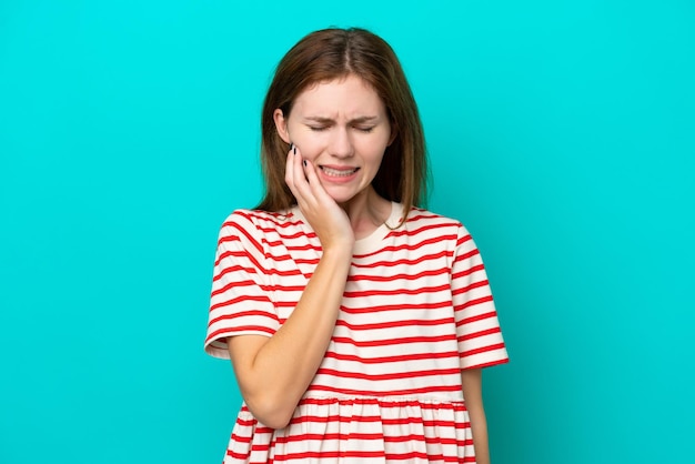 Giovane donna inglese isolata su sfondo blu con mal di denti