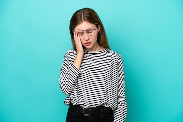 Giovane donna inglese isolata su sfondo blu con mal di testa