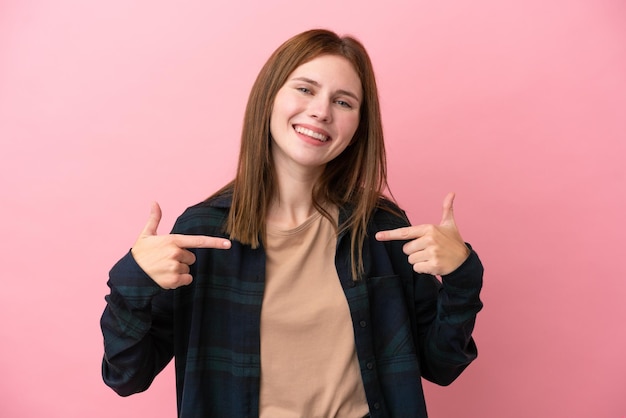Giovane donna inglese isolata su sfondo rosa orgogliosa e soddisfatta