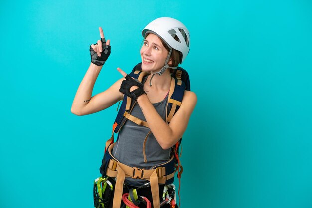 Giovane donna inglese rock climber isolata su sfondo blu che punta con il dito indice una grande idea