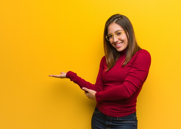 Giovane donna intellettuale che tiene qualcosa con le mani