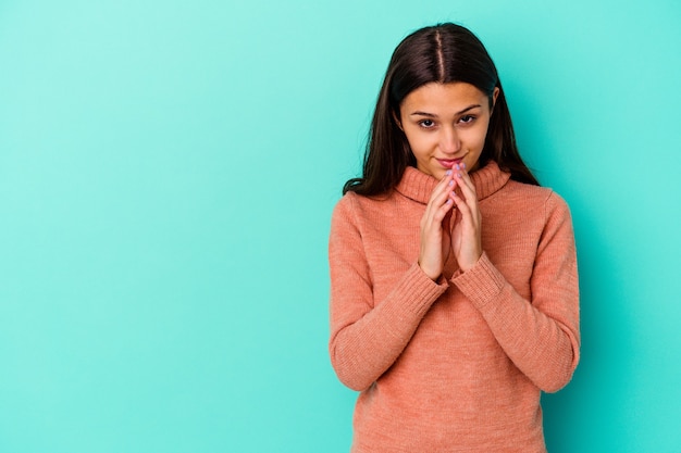 Giovane donna isolata sulla parete blu che compongono il piano in mente, creando un'idea