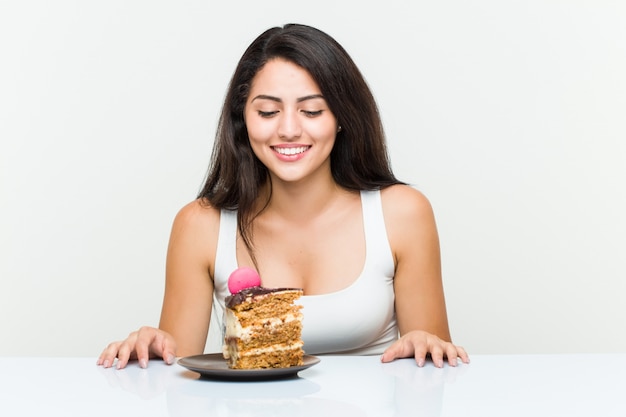 Giovane donna ispanica che mangia un dolce alle carote