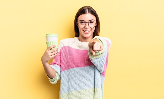 Giovane donna ispanica che punta alla telecamera scegliendo te. portare via il concetto di caffè