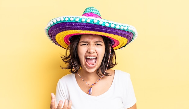 Giovane donna ispanica che sembra arrabbiata, infastidita e frustrata. concetto di cappello messicano