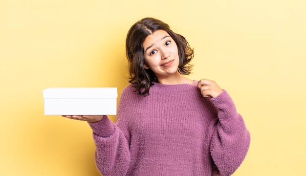 Giovane donna ispanica che sembra arrogante, di successo, positiva e orgogliosa. concetto di scatola vuota