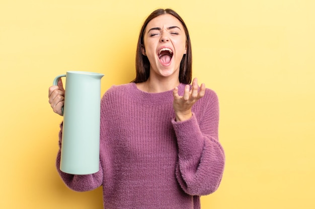 Giovane donna ispanica che sembra disperata, frustrata e stressata, concetto di thermos per caffè