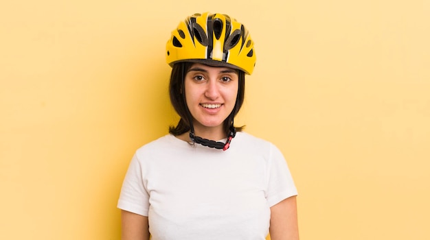 Giovane donna ispanica che sembra felice e piacevolmente sorpresa concetto di casco da bici