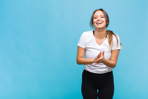 Giovane donna ispanica che si sente felice e di successo, sorride e applaude le mani, dicendo congratulazioni con un applauso