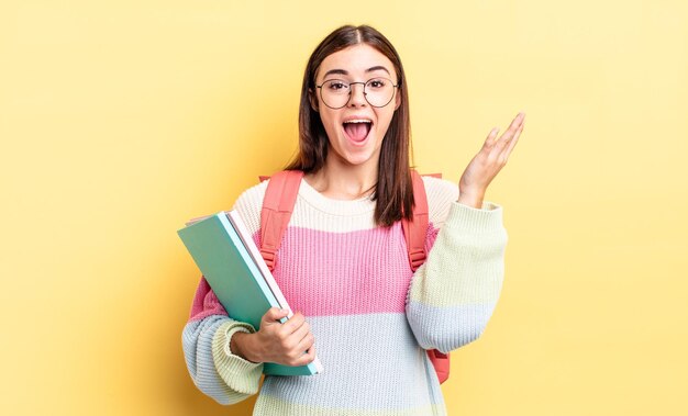 Giovane donna ispanica che si sente felice, sorpresa nel realizzare una soluzione o un'idea. concetto di studente