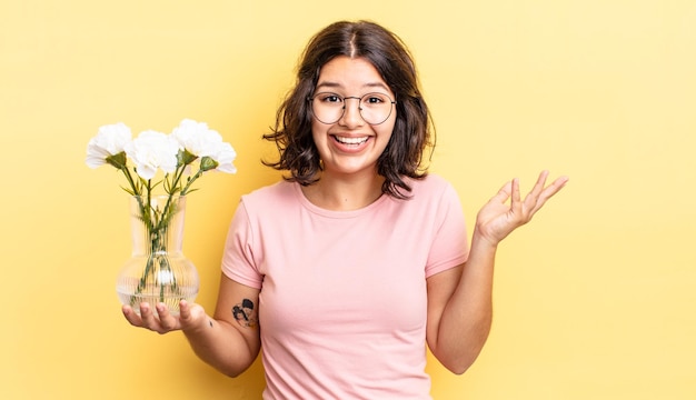 Giovane donna ispanica che si sente felice, sorpresa nel realizzare una soluzione o un'idea. concetto di vaso di fiori