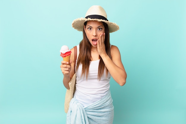 Giovane donna ispanica che si sente scioccata e spaventata e tiene in mano un gelato. concetto estivo