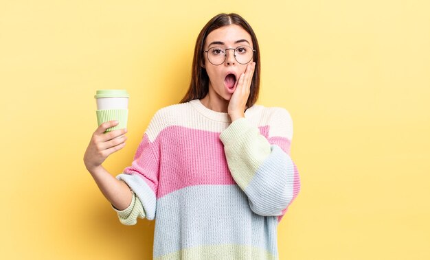 Giovane donna ispanica che si sente scioccata e spaventata. portare via il concetto di caffè