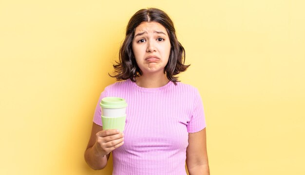 Giovane donna ispanica che si sente triste e lamentosa con uno sguardo infelice e piange porta via il concetto di caffè