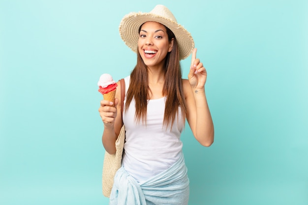 Giovane donna ispanica che si sente un genio felice ed eccitato dopo aver realizzato un'idea e aver tenuto un gelato. concetto estivo