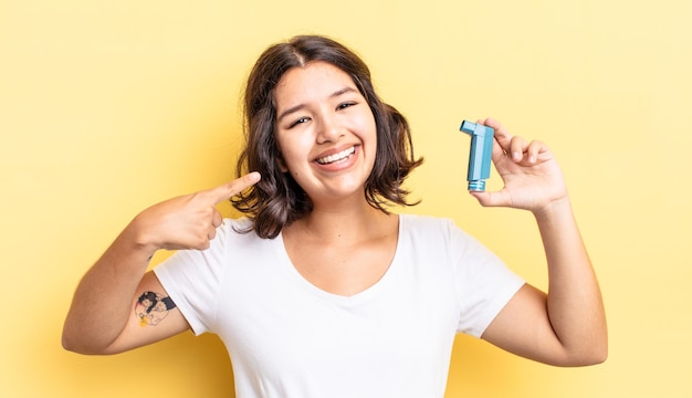 Giovane donna ispanica che sorride con sicurezza indicando il proprio ampio sorriso. concetto di asma