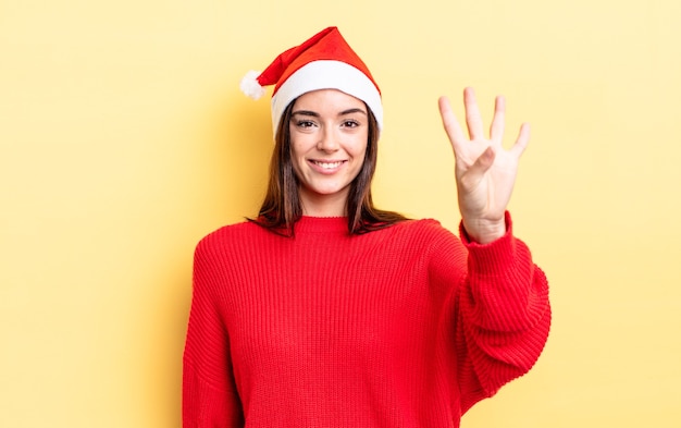 Giovane donna ispanica che sorride e che sembra amichevole, mostrando il numero quattro. concetto di natale e capodanno