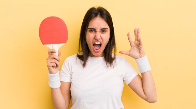 Giovane donna ispanica che urla con le mani in alto nel concetto di ping pong in aria