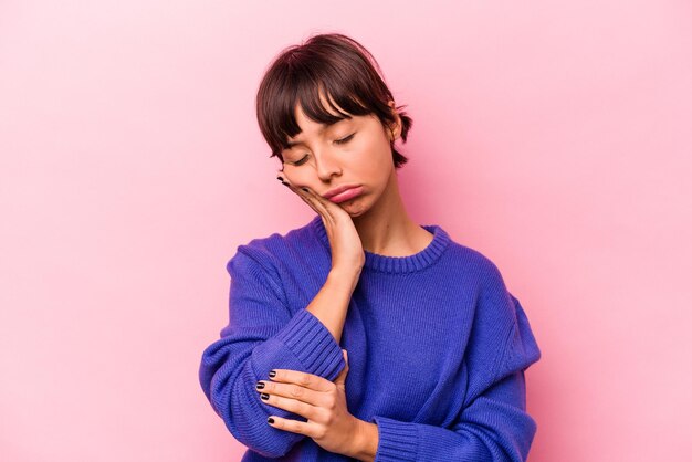 Giovane donna ispanica isolata su sfondo rosa che è annoiata affaticata e ha bisogno di una giornata di relax