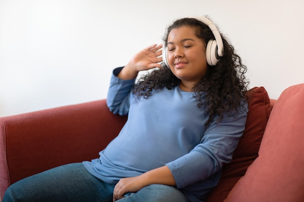 Giovane donna ispanica rilassata più dimensioni che ascolta la musica