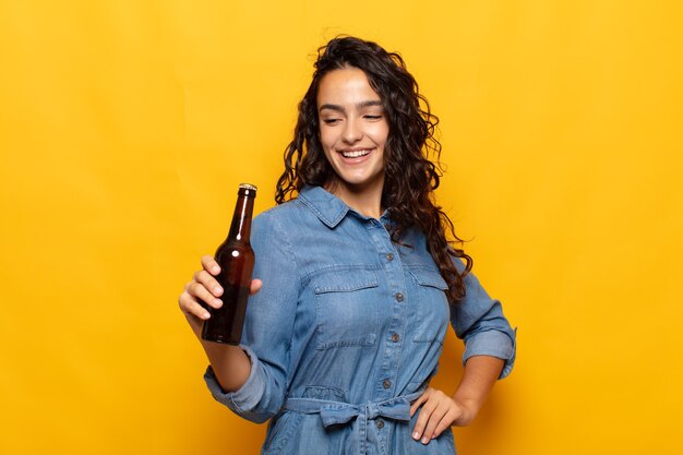 Giovane donna ispanica sorridente felicemente e fantasticando o dubitando, guardando al lato