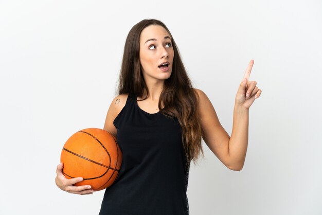 Giovane donna ispanica su sfondo bianco isolato giocando a basket e avendo un'idea