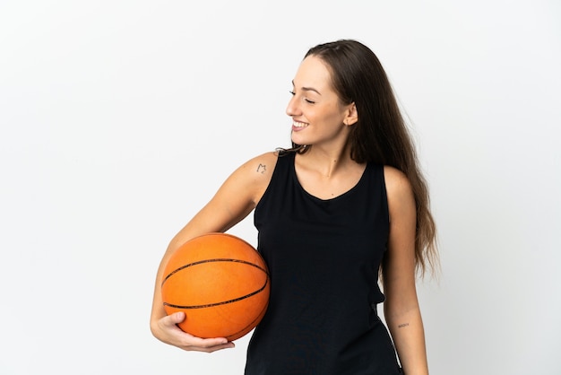 Giovane donna ispanica su sfondo bianco isolato, giocare a basket