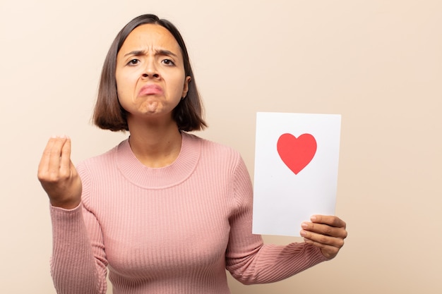 Giovane donna latina che fa un gesto di capice o denaro, dicendoti di pagare i tuoi debiti!