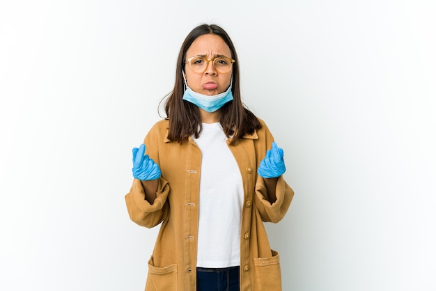 Giovane donna latina che indossa una maschera per proteggere da covid isolato sul muro bianco che mostra che non ha soldi.