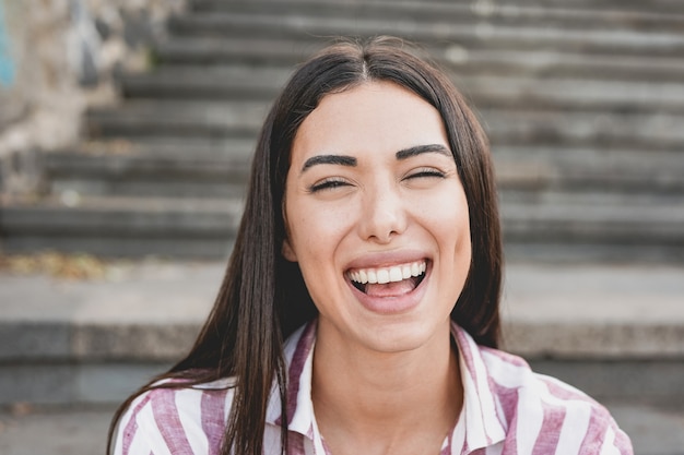 Giovane donna latina che ride sulla macchina fotografica. Concetto di felicità