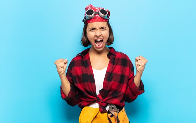 Giovane donna latina che si sente felice, positiva e di successo, celebra la vittoria, i risultati o la buona fortuna