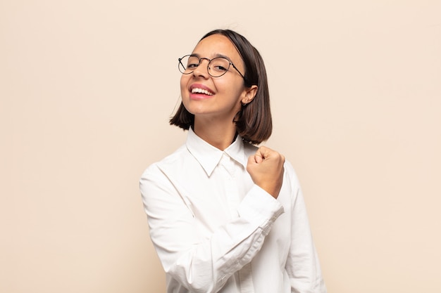 Giovane donna latina che si sente felice, positiva e di successo, motivata quando affronta una sfida o celebra buoni risultati